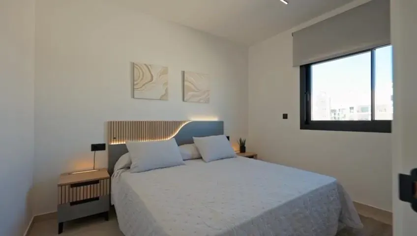 Tweede slaapkamer met tweepersoonsbed en raam op het zuiden