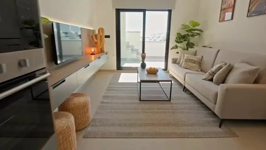 Lichte woonkamer met open keuken in vakantieappartement Casa Oasis Laguna, Guardamar del Segura